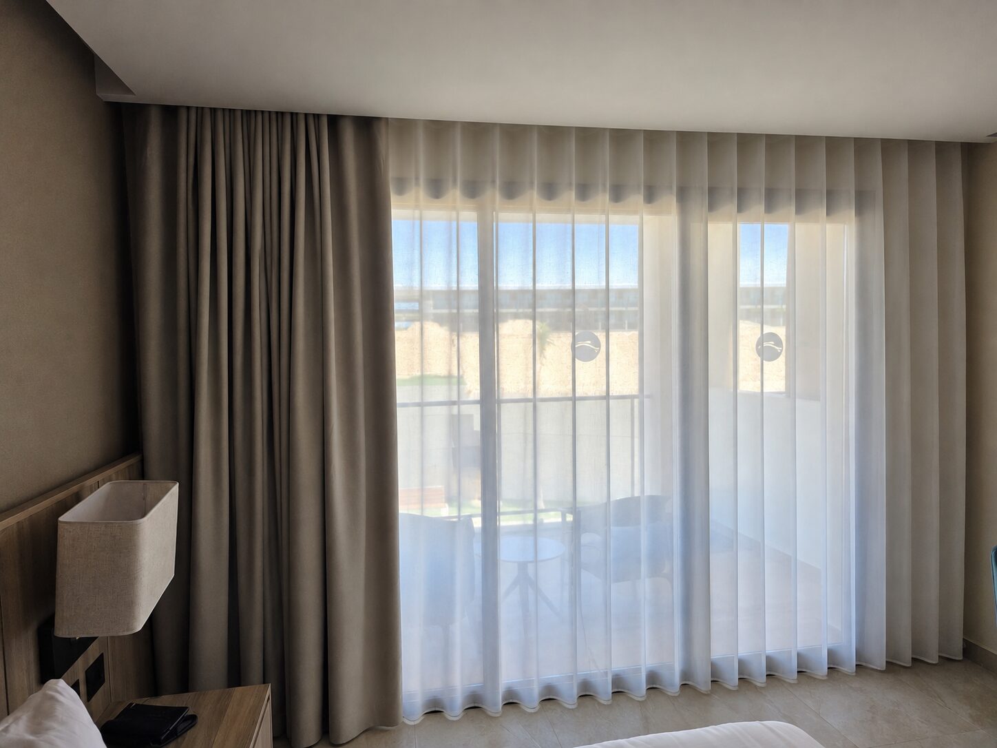 Cortinas Onda Perfecta con tela traslúcida blanca y paño lateral gris, con ondas regulares de techo a piso