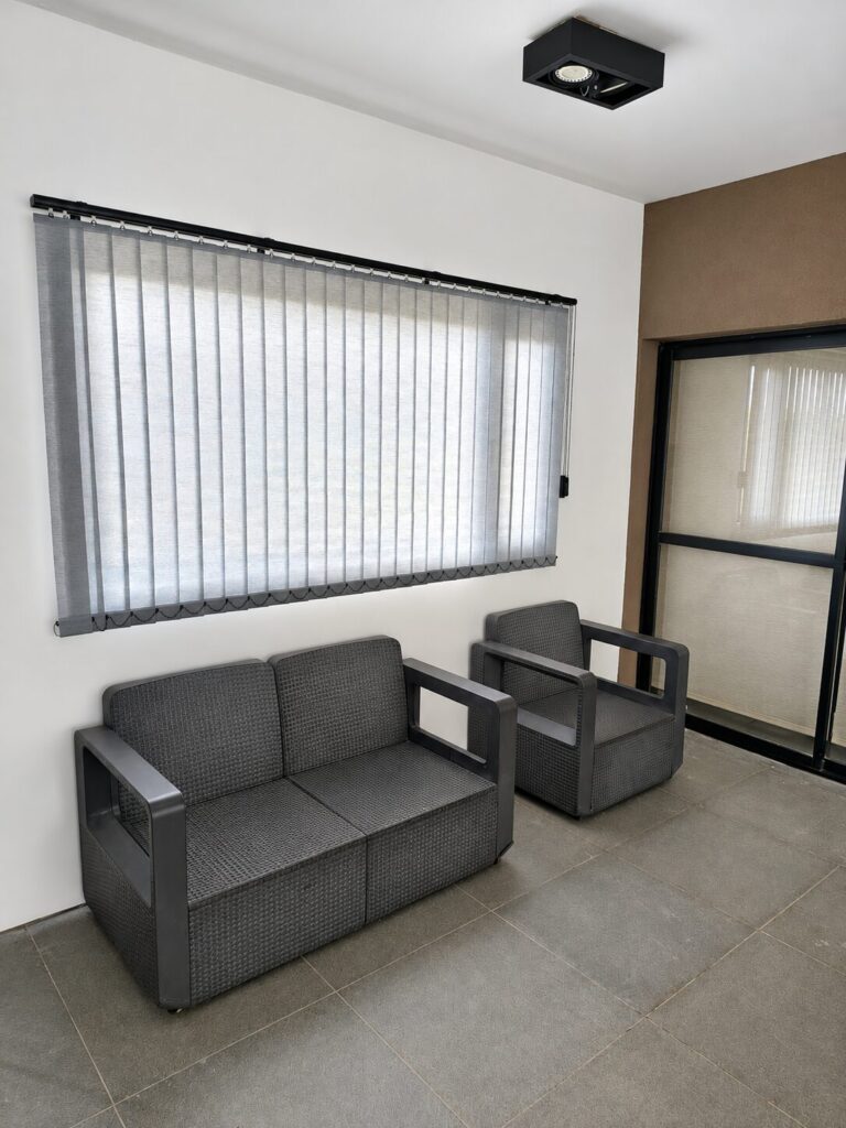 Bandas Verticales South Beach en ventana junto a sillones