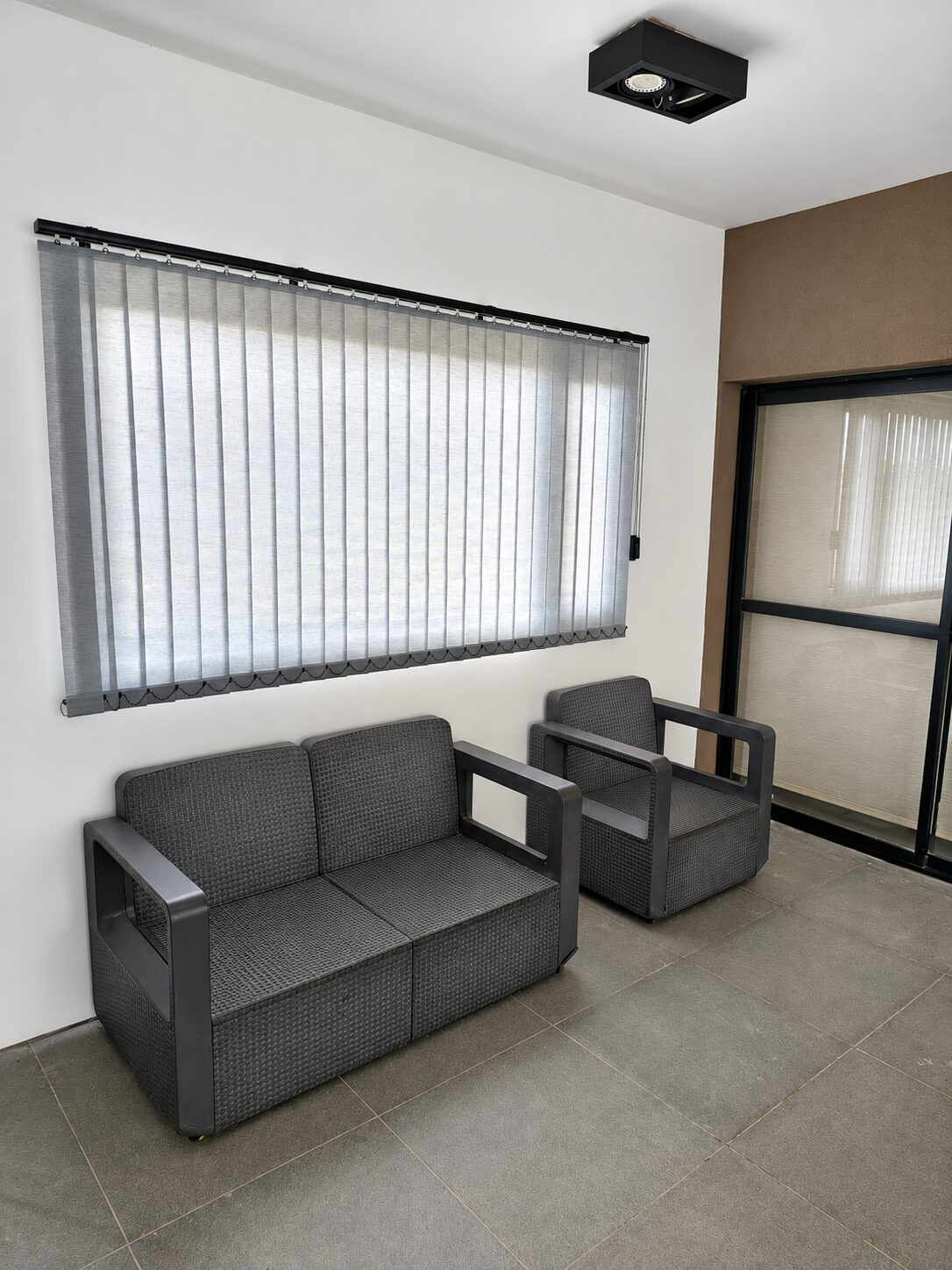 Bandas verticales South Beach en ventana junto a sillones